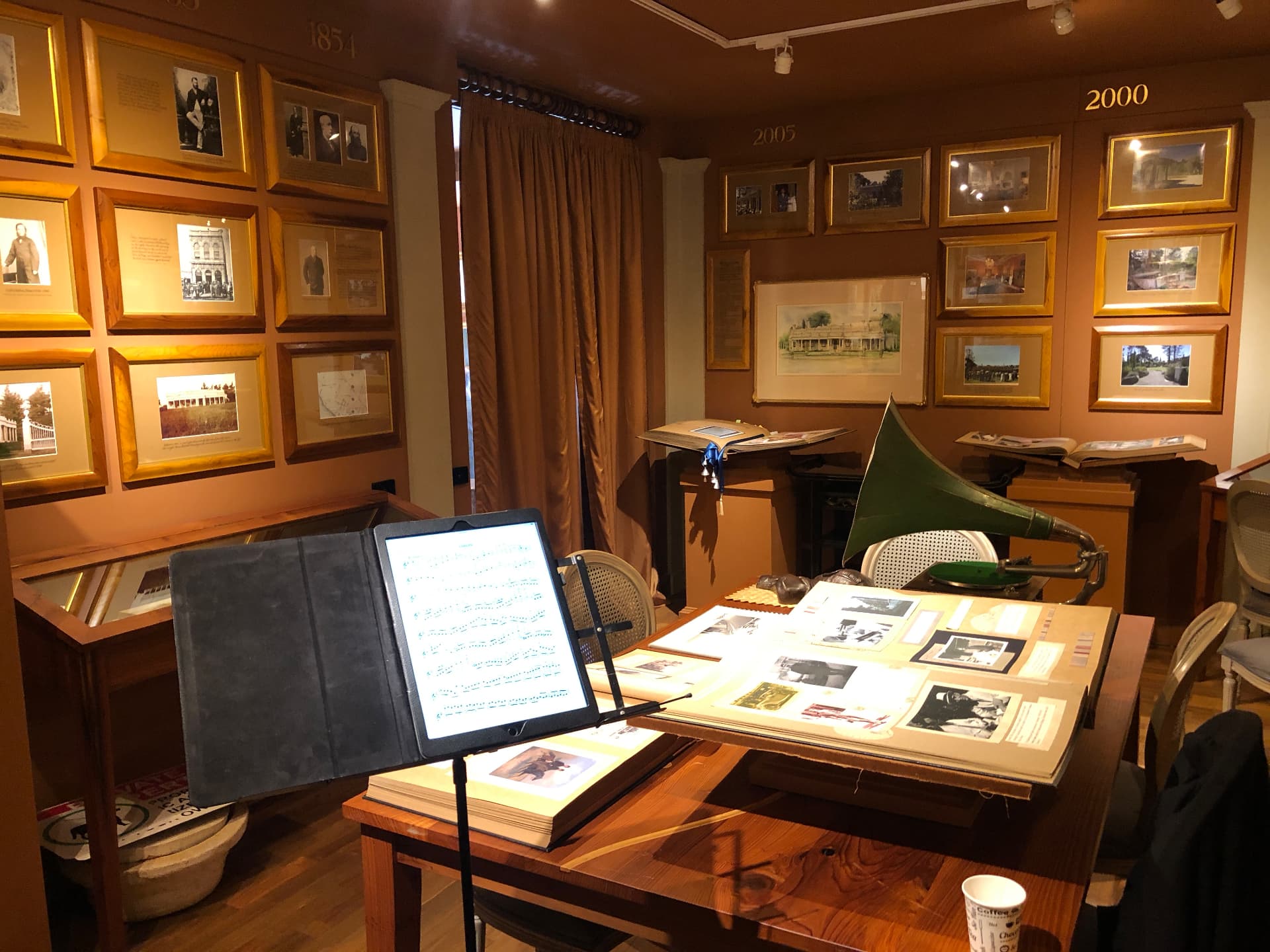 Music room with framed archive photographs, sheet music on a stand and a gramophone