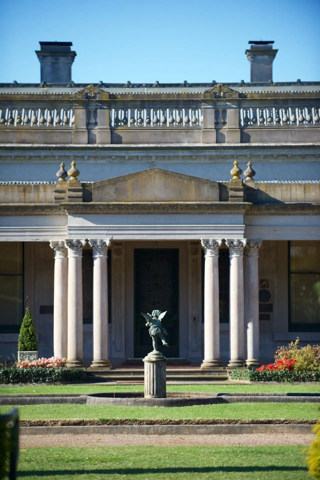 Corinthian colonnade of the heritage mansion with a bronze cherub fountain on the lawn