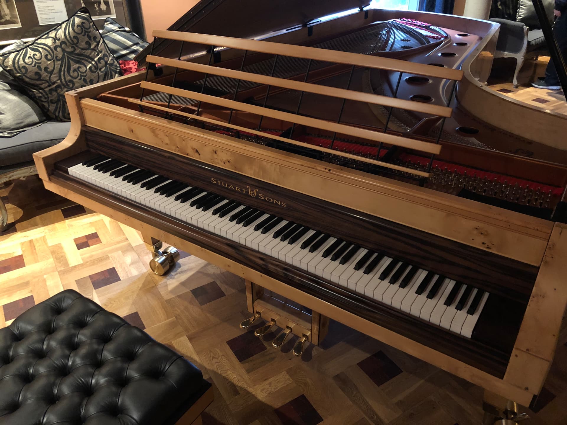Stuart & Sons grand piano with its lid open in a music room