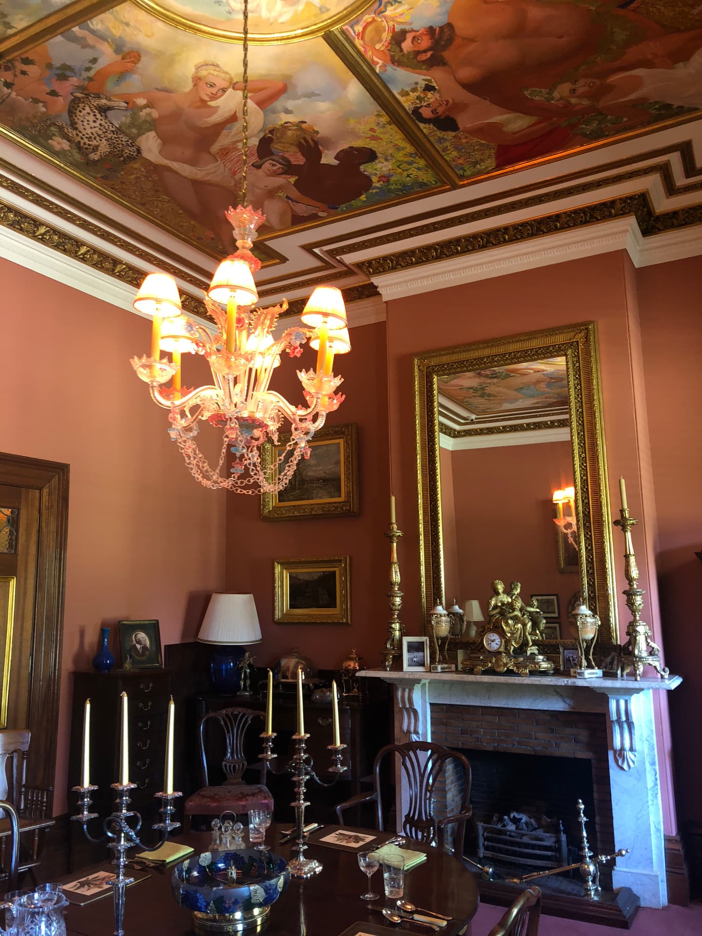 Formal dining room with painted ceiling mural, chandelier and marble fireplace