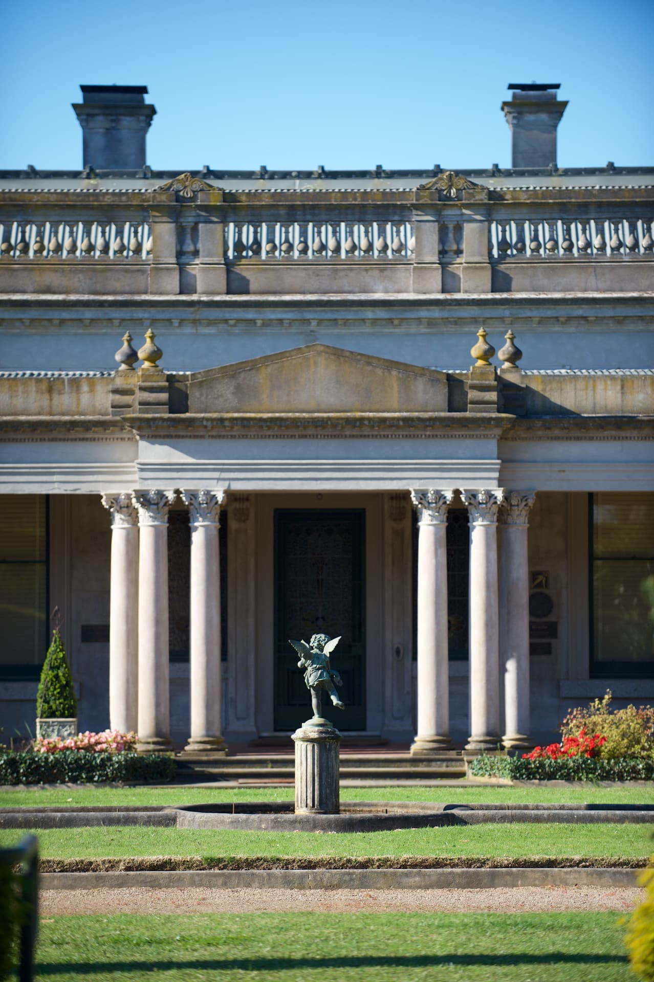 Corinthian colonnade of the heritage mansion with a bronze cherub fountain on the lawn